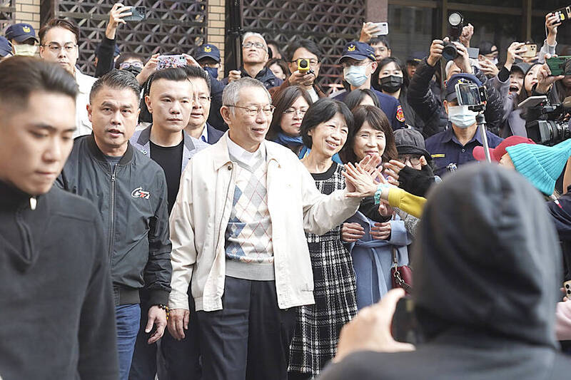 
Taiwan People’s Party Chairman Ko Wen-je, center, waves to supporters as he leaves the Taipei District Court yesterday.
Photo: CNA