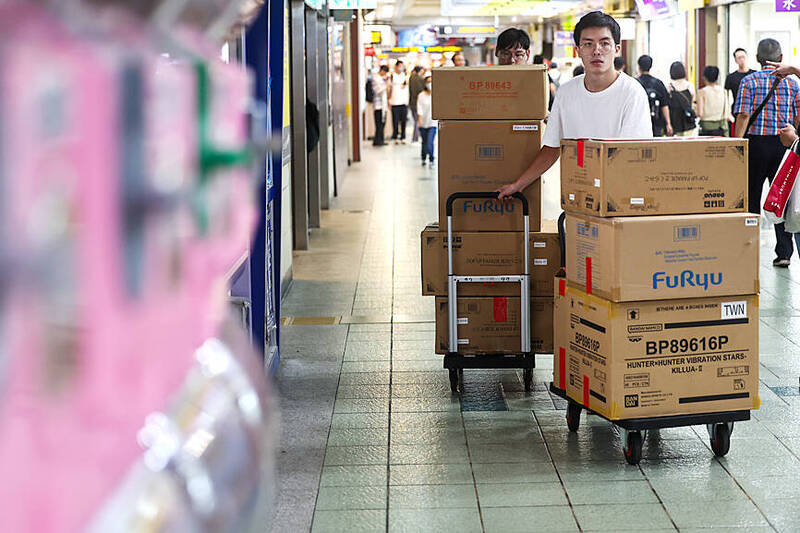 
A man pushes carts full of goods in Taipei’s Zhongzheng District on Sept. 23.
Photo: CNA