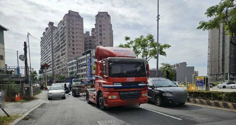 王男騎機車超車不慎擦撞曳引車右後輪，再擦撞路邊停放2輛轎車。（讀者提供）