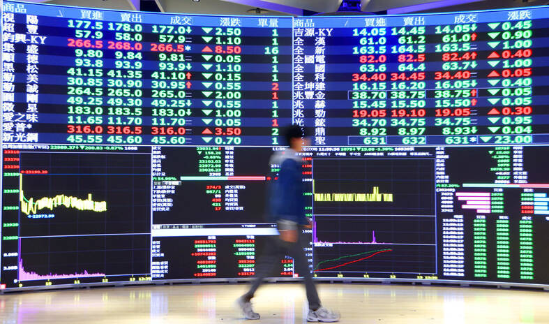 A man walks past an electronic stock board at the Taiwan Stock Exchange in Taipei yesterday.
Photo: CNA