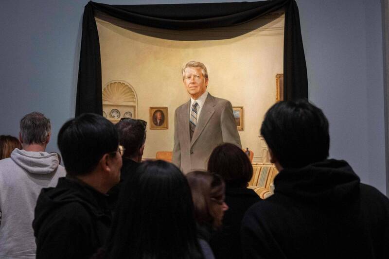 白宮橢圓形辦公室掛著美國前總統卡特的肖像，肖像披著黑色喪服。（法新社）