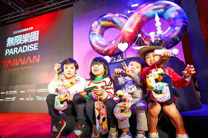 
Children hold lanterns to be given out during the Lantern Festival in front of a model of the main festival’s lantern during a news conference promoting the event yesterday in Taipei.
Photo: CNA