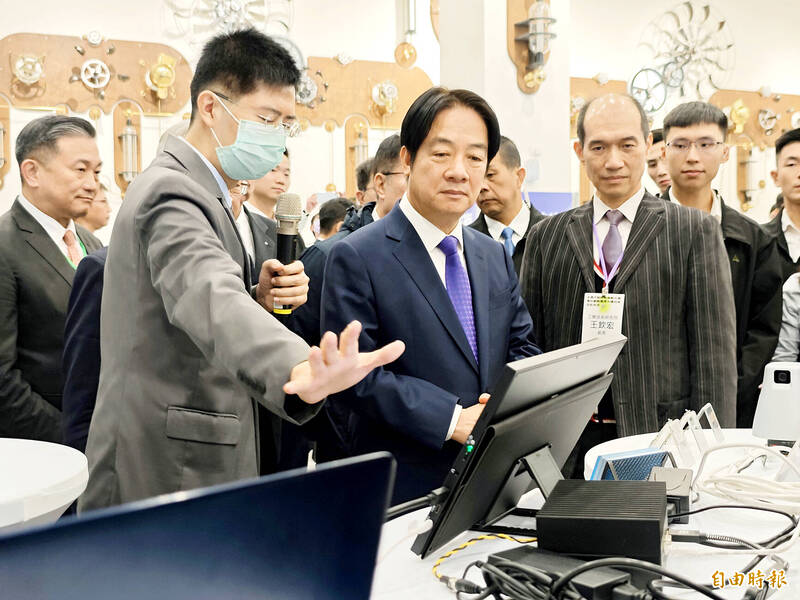 
President William Lai, center, views a computer terminal in Tainan yesterday.
Photo: Wu Chun-feng, Taipei Times