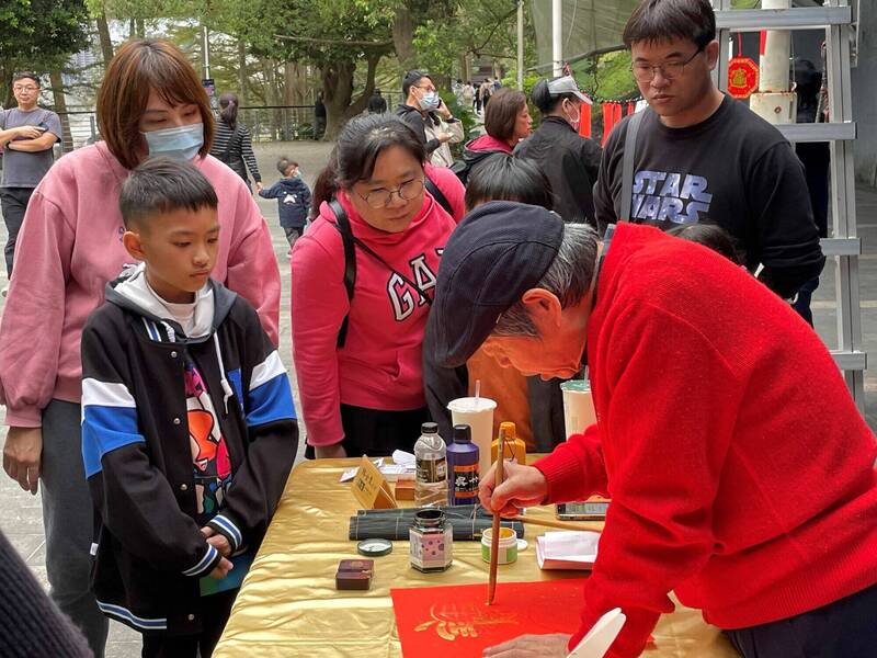 民眾近距離欣賞書法藝術獨特之美及大師揮毫的氣勢，圖為去年贈春聯活動資料照。（圖由新北市觀旅局提供）