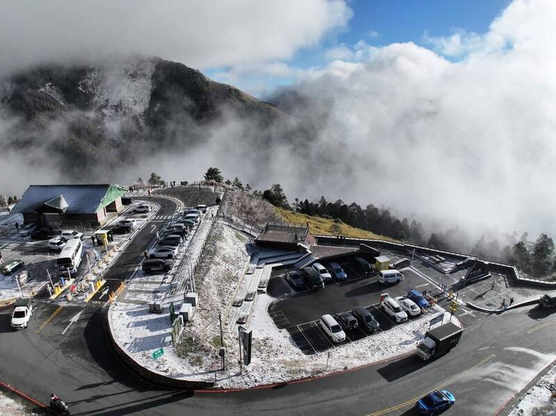 網友以空拍機鳥瞰合歡山昆陽的雪景，中間染白，四周則籠罩山嵐，景致迷人。（黃哲提供）