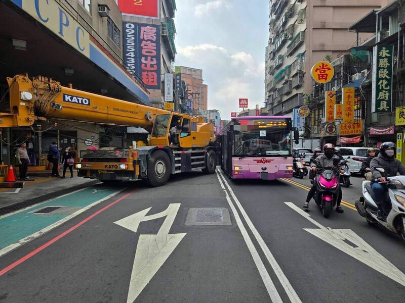 孫男駕駛吊臂車行駛新北市中和區景平路，準備右轉進入加油站時，因迴轉半徑過大，不慎與欣欣客運607號公車陳姓駕駛擦撞。（記者陸運鋒翻攝）