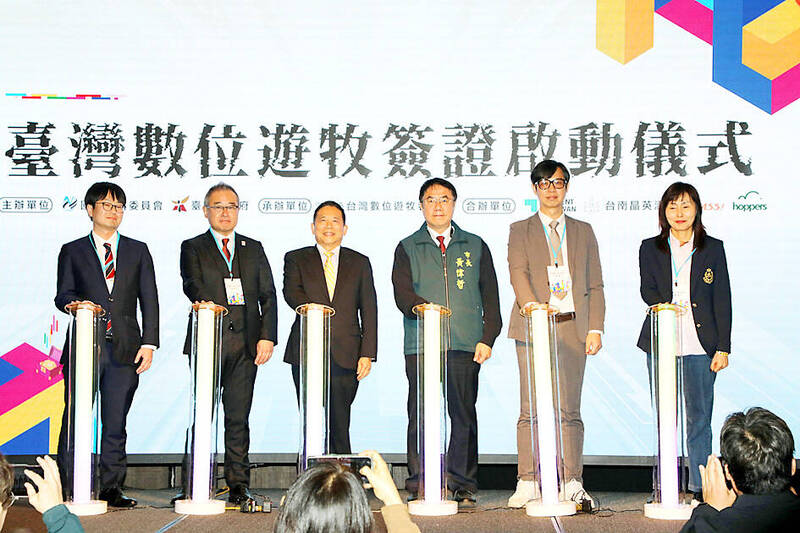 National Development Council Minister Paul Liu, third left, Tainan Mayor Huang Wei-che, third right, and other guests attend an event in Tainan on Dec. 20 last year to promote the new “digital nomad visa.”
Photo: CNA