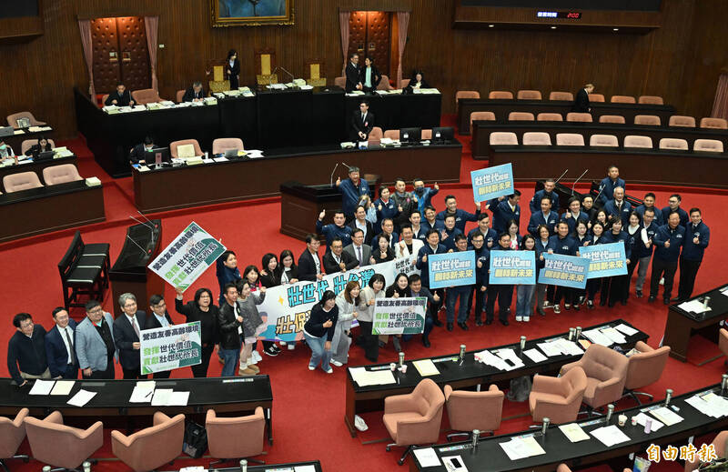 立法院長韓國瑜敲下議事槌，宣布壯世代政策產業發展條例三讀通過，3黨立委難得在議場共同舉牌慶祝並合照。（記者田裕華攝）