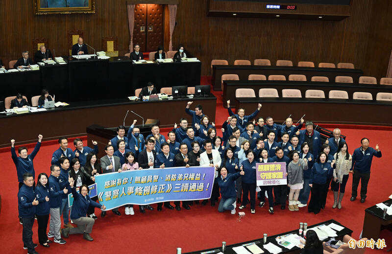 立法院長韓國瑜敲下議事槌，警察人員人事條例三讀通過，國民黨與民眾黨立委在議場共同舉牌慶祝並合照。（記者田裕華攝）