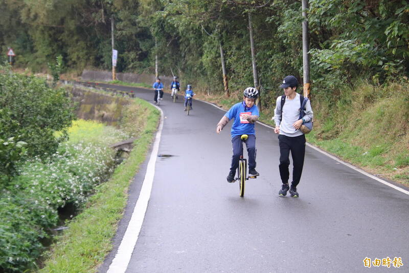 一對父子，1個騎獨輪車，1個慢跑，一路緊緊相隨。（記者黃美珠攝）