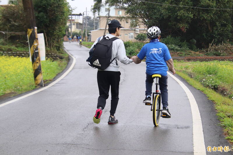 一對父子，1個騎獨輪車，1個慢跑，一路緊緊相隨。（記者黃美珠攝）