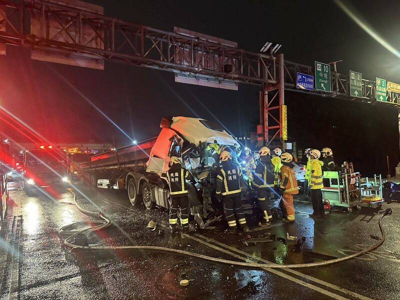 桃園市國2道大園東側交流道入口處發生曳引車追撞曳引車事故，後車車頭嚴重變形，消防救護人員搶救受困車內的黃姓駕駛。（記者余瑞仁翻攝）（記者余瑞仁攝）