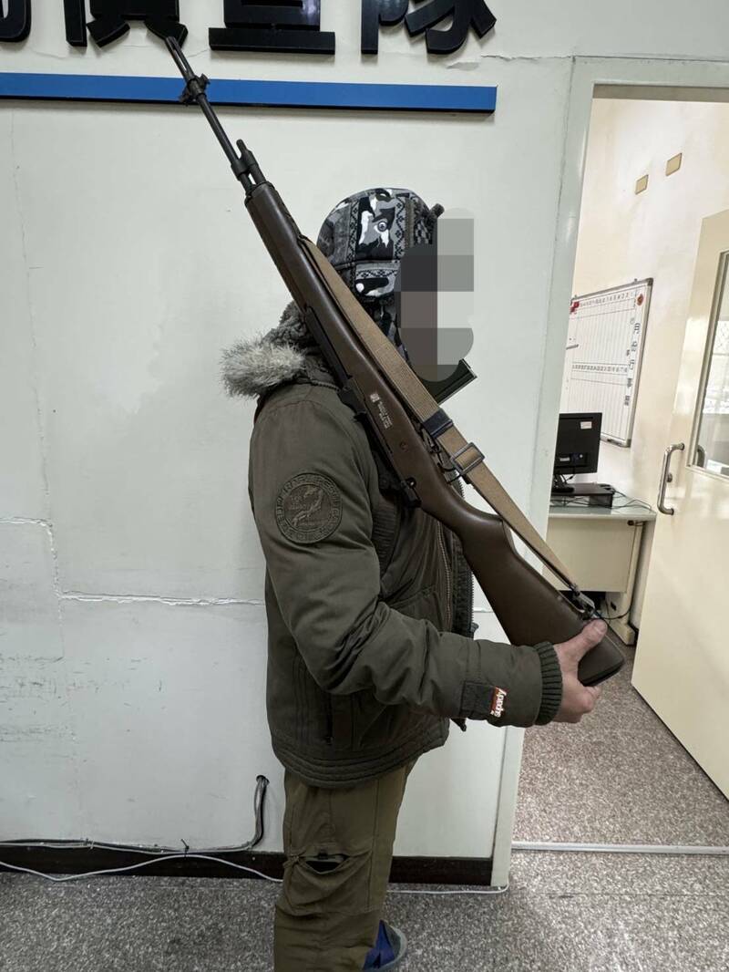 陳姓男子扛著生存遊戲玩具槍,站在合歡山武嶺亭「鏡頭君」前留影,26日主動出面說明。(警方提供) 陳姓男子扛著生存遊戲玩具槍,站在合歡山武嶺亭「鏡頭君」前留影,26日主動出面說明。(警方提供)
