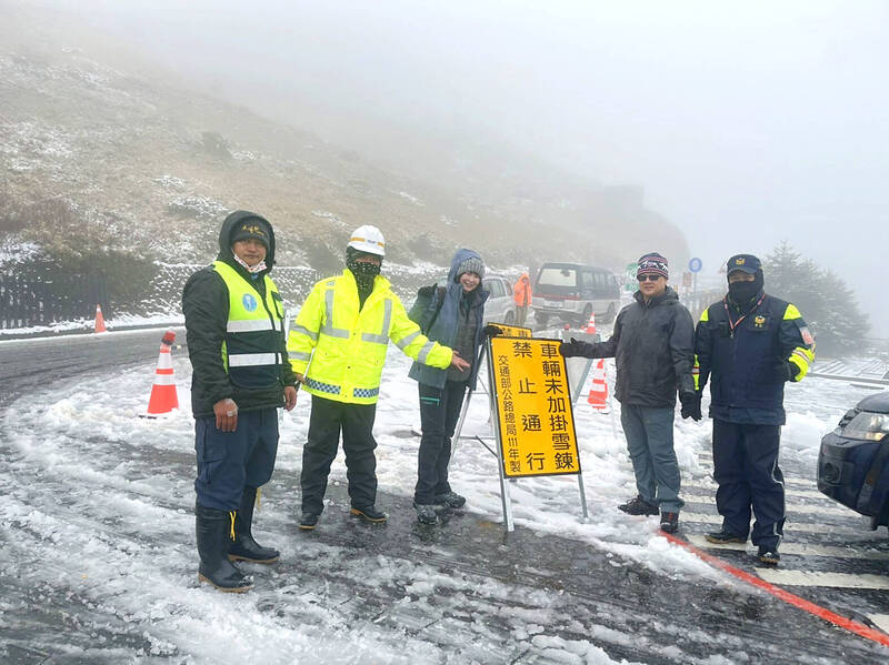 Police on Sunday stand next to a sign that bans vehicles from enterning Hehuanshan in Nantou Coutny without snow tire chains when there is snow in the mountains.
Photo courtesy of the Taroko National Park Administration Center via CNA
Police on Sunday stand next to a sign that bans vehicles from enterning Hehuanshan in Nantou Coutny without snow tire chains when there is snow in the mountains.
Photo courtesy of the Taroko National Park Administration Center via CNA