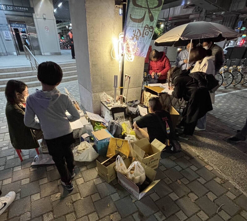 罷團在中捷站外協助民眾填寫提議書，既使下雨也不能踏進站區。（圖由志工提供）