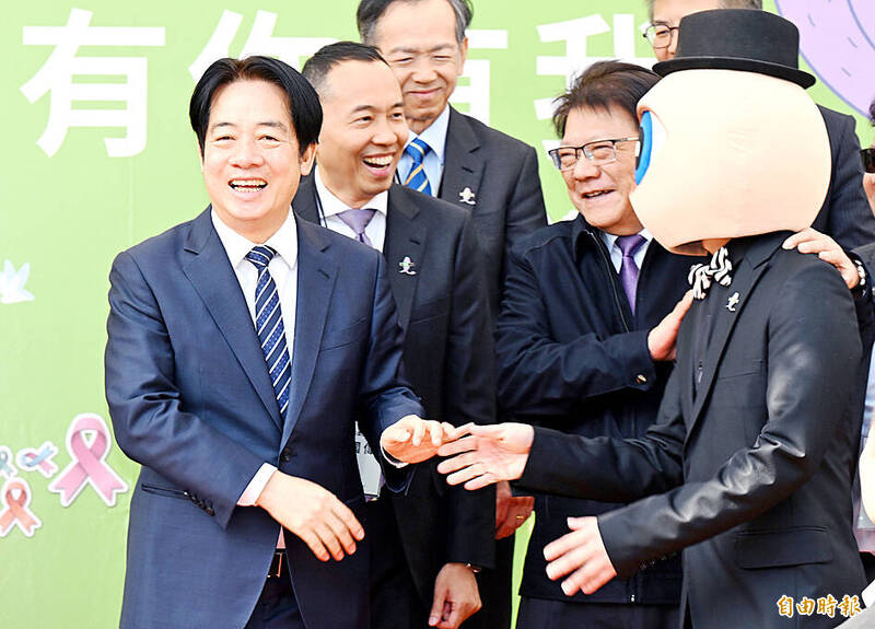 
President William Lai, left, laughs while talking to the artist Mr Eyeball, right, at an event marking World Cancer Day at Huashan 1914 Creative Park in Taipei yesterday. 
Photo: Liao Chen-huei, Taipei Times