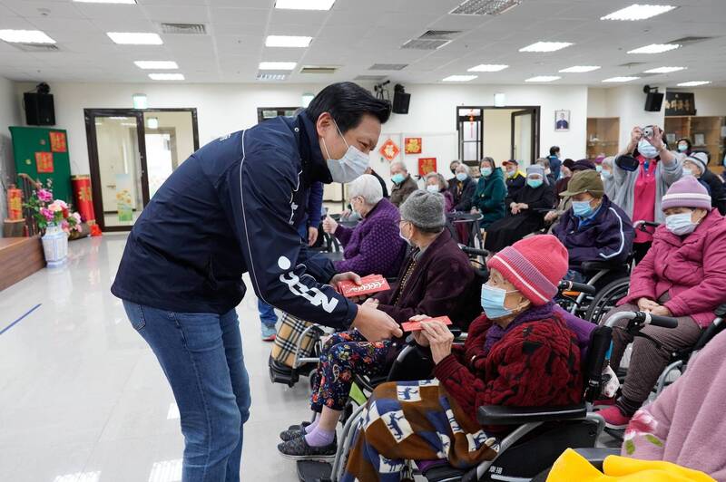 新北市副市長朱惕之致贈小福袋給安老院103歲劉奶奶。（新北市社會局提供）