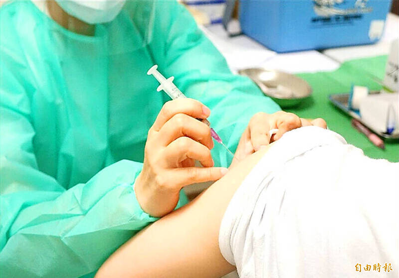 A medical worker administers a vaccine in an undated photograph.
Photo: Taipei Times