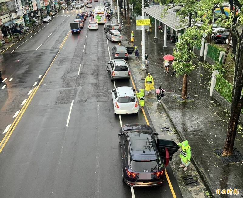 台中霧峰區霧峰國小交通組志工,不論晴天、雨天都幫小朋友開車門,加快速度避免塞車。(記者陳建志攝) 台中霧峰區霧峰國小交通組志工,不論晴天、雨天都幫小朋友開車門,加快速度避免塞車。(記者陳建志攝)