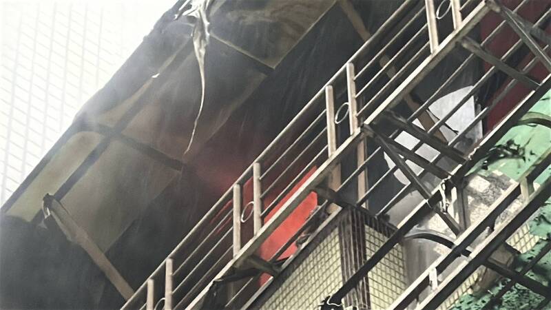 現場火舌竄出，消防隊員趕緊佈線射水。（記者吳昇儒翻攝）