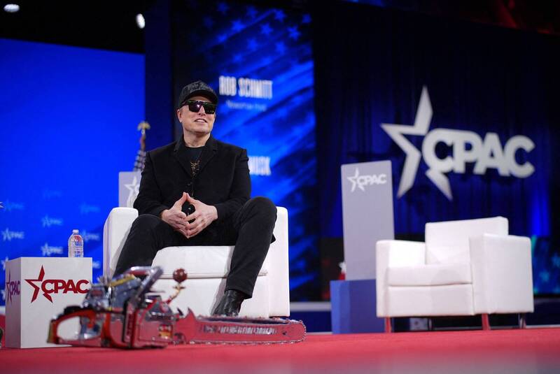 馬斯克戴著太陽眼鏡和「讓美國再次偉大」（Make America Great Again）黑色帽子登台（法新社）。
