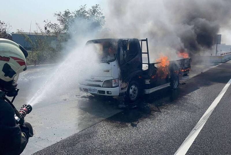 國1彰化戰備道上午發生小貨車火燒車事件，火勢一度相當猛烈，消防員噴水灌救。 （消防局提供）