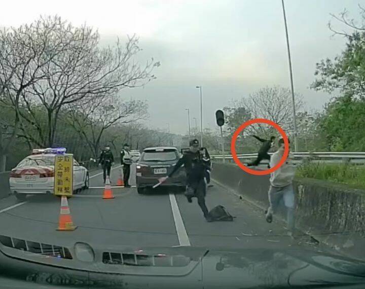 國道警76快速道路臨檢,一輛休旅車突然蹦出6人,有人往反方向狂奔,有人跳護欄逃跑(紅圈處)。(翻攝網路) 國道警76快速道路臨檢,一輛休旅車突然蹦出6人,有人往反方向狂奔,有人跳護欄逃跑(紅圈處)。(翻攝網路)
