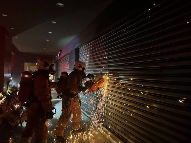 消防人員從1樓店面破門進入灌救。（消防局提供）