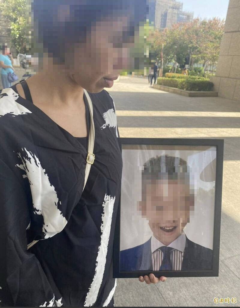 辛女捧著5歲兒子遺照出席調解庭。(資料照) 辛女捧著5歲兒子遺照出席調解庭。(資料照)