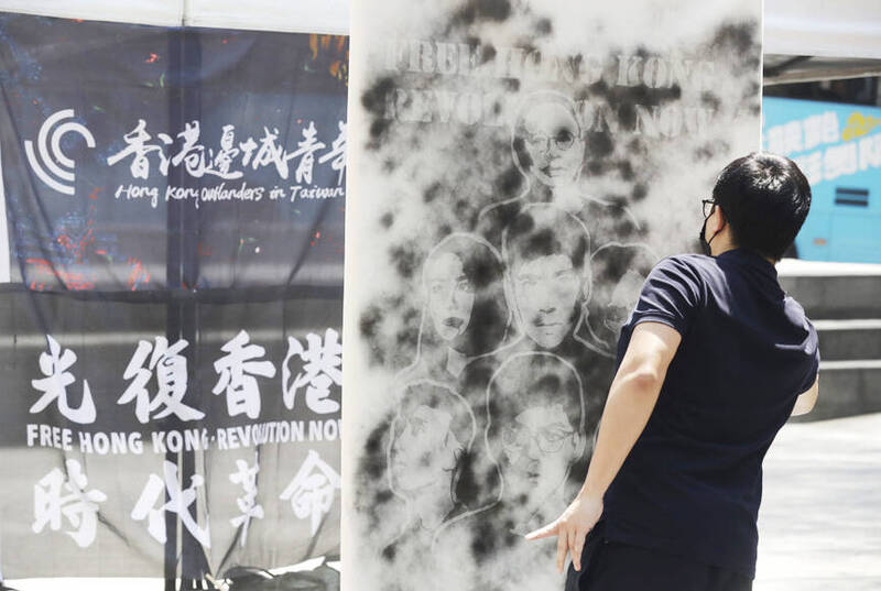 A Hong Kong activist spray-paints an image of the “Hong Kong 47” democracy advocates in Taipei yesterday during a protest commemorating the anniversary of the implementation of Article 23 of the Hong Kong Basic Law.
Photo: Chiang Ying-ying, AP
A Hong Kong activist spray-paints an image of the “Hong Kong 47” democracy advocates in Taipei yesterday during a protest commemorating the anniversary of the implementation of Article 23 of the Hong Kong Basic Law.
Photo: Chiang Ying-ying, AP