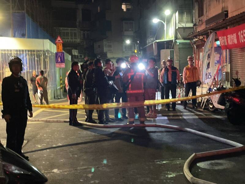 北市信義區舊公寓大樓頂加深夜惡火，消防人員漏夜灌救。（記者邱俊福翻攝）