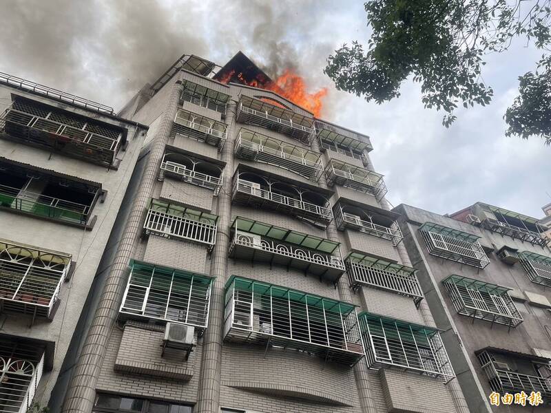 新北市深坑區文化路7層樓華廈頂樓鐵皮屋，今日下午突然起火。（記者鄭景議攝）