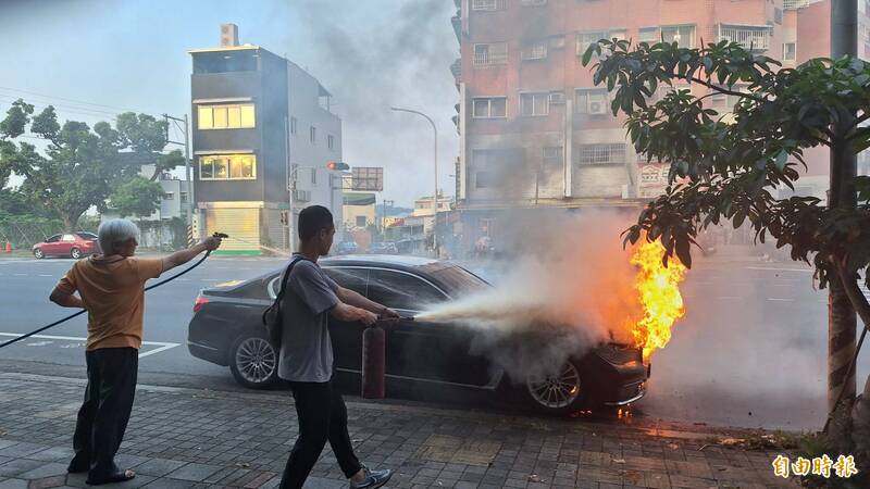 1輛BMW轎車29日下午行經南投市區突起火燃燒,熱心民眾持水管引水協助滅火。(記者張協昇攝) 1輛BMW轎車29日下午行經南投市區突起火燃燒,熱心民眾持水管引水協助滅火。(記者張協昇攝)