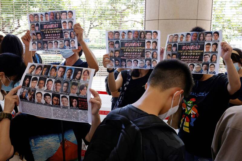 香港歷來規模最大的國安案件「47人案」首批被判刑4名被告今天刑滿出獄,至今仍有多人身繫獄中,圖為2021年時支持者在法院外舉標語,呼籲拯救47人的資料畫面。(路透) 香港歷來規模最大的國安案件「47人案」首批被判刑4名被告今天刑滿出獄,至今仍有多人身繫獄中,圖為2021年時支持者在法院外舉標語,呼籲拯救47人的資料畫面。(路透)