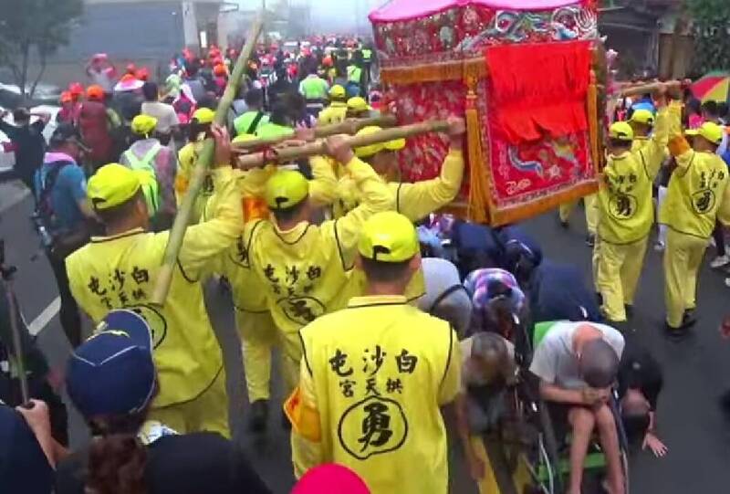 白沙屯媽祖「粉紅超跑」鑾轎,7日沿著南投名間鄉境內的139乙線前行,民眾爭相鑽轎底祈福。(截取自白沙屯媽祖網路直播電視台) 白沙屯媽祖「粉紅超跑」鑾轎,7日沿著南投名間鄉境內的139乙線前行,民眾爭相鑽轎底祈福。(截取自白沙屯媽祖網路直播電視台)