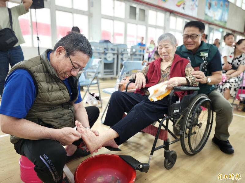 男子為行動不便的母親沐足,場面感人。(記者吳俊鋒攝) 男子為行動不便的母親沐足,場面感人。(記者吳俊鋒攝)