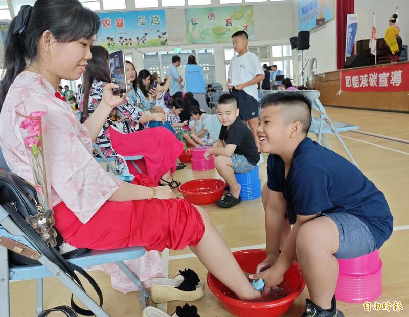 今年也邀請新住民家庭參加,小朋友開心地為母親洗腳。(記者吳俊鋒攝) 今年也邀請新住民家庭參加,小朋友開心地為母親洗腳。(記者吳俊鋒攝)