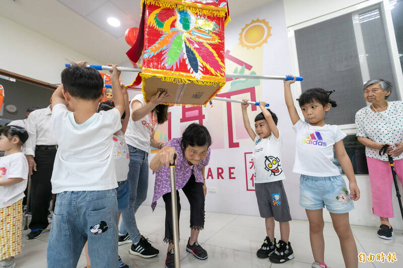 幼兒園學童還用紙箱製作媽祖鑾轎,讓阿公阿嬤鑽轎祈福,溫馨有趣。(記者張軒哲攝) 幼兒園學童還用紙箱製作媽祖鑾轎,讓阿公阿嬤鑽轎祈福,溫馨有趣。(記者張軒哲攝)
