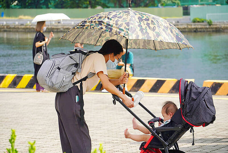 A woman tends to a child in a stroller at the Port of Kaohsiung in an undated photograph.
Photo: CNA
A woman tends to a child in a stroller at the Port of Kaohsiung in an undated photograph.
Photo: CNA