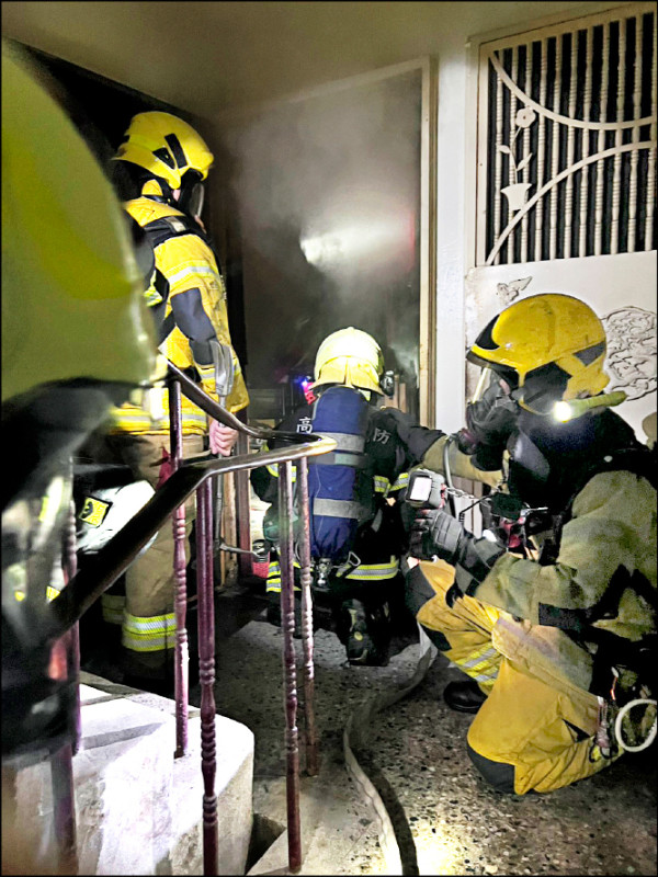 高雄市鳳山區國泰路一棟五樓公寓發生火警，消防員
從二樓救出一對昏迷父子送醫。（記者蔡清華翻攝）