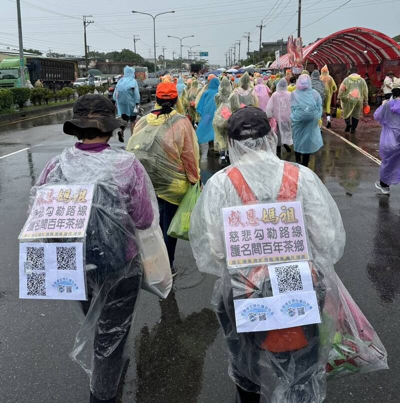 白沙屯媽祖於南投名間鄉遶境時，信眾背著「感謝媽祖慈悲勾勒路線護名間百年茶鄉」標語牌。（民眾提供）
