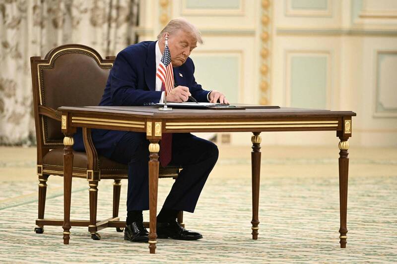 美國總統川普在利雅德期間簽署文件。（法新社）