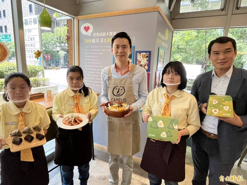 新竹縣竹北市長鄭朝方（中）日化身「SEFUN CAFÉ 喜歡你餐坊」1日店長，與喜憨兒基金會庇護員工一同大秀廚藝，展示該店最新推出的特色料理和端午節禮盒，邀請市民有新台幣下架憨兒們用心製作的美味商品。 （記者廖雪茹攝）