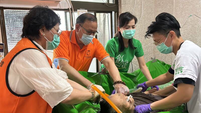 禾繕基金會董事長毛卉瑜(左1)和天麗生技執行長王宗易(左2)參與創世到宅服務,為植物人原床泡澡。(創世基金會提供) 禾繕基金會董事長毛卉瑜(左1)和天麗生技執行長王宗易(左2)參與創世到宅服務,為植物人原床泡澡。(創世基金會提供)