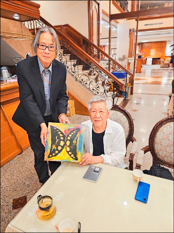 張家銘（站者）贈送他畫的蝴蝶給吉川浩司。（鎮寶大飯店提供）