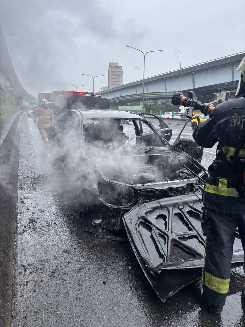 消防人員封鎖路肩並進行灌救。（記者徐聖倫翻攝）