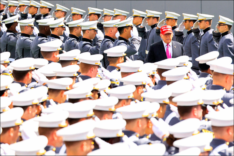 美國總統川普（中，戴紅帽者）24日也前往紐約西點軍校畢業典禮演講。（法新社）