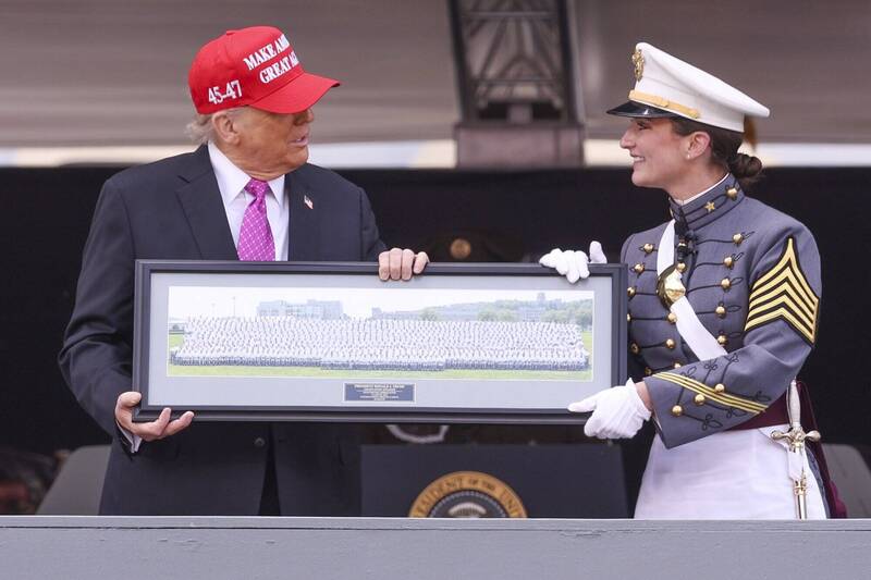 美國總統川普（左）出席西點軍校畢業典禮，致詞後獲畢業生班長 Katherine LaReau （右）代表獻上2025年班合照作為紀念。（歐新社）
