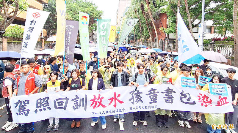 
People hold banners during a protest held by traffic advocacy groups in Taipei yesterday.
Photo: Fang Pin-chao, Taipei Times