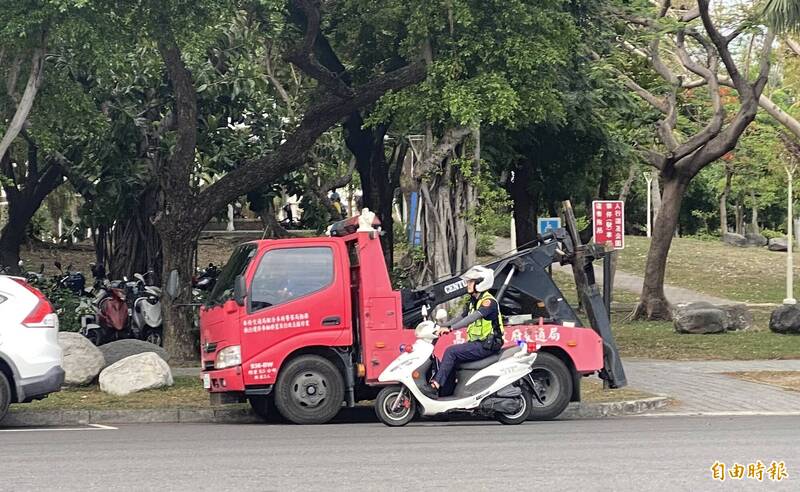 拖吊車一旁待命，員警不斷巡邏維持機場周遭交通秩序。（記者洪臣宏攝）